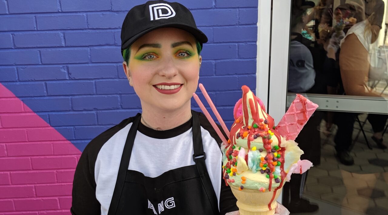 DANG Ice Cream worker shows off colorful cone.